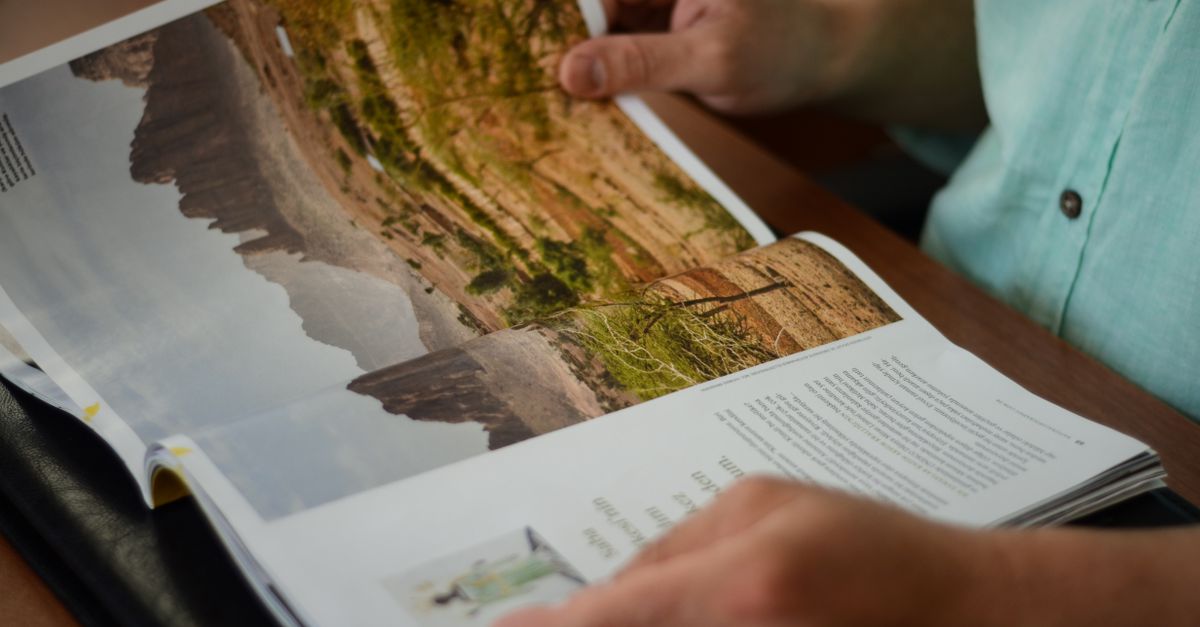 Person reading detailed product documentation at a desk before making a purchase decision